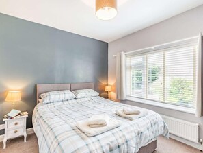 A bedroom with a bed, bedside lamps, a nightstand, and a window with blinds. - 2 Bed in Filey (oc-49508) (Filey)