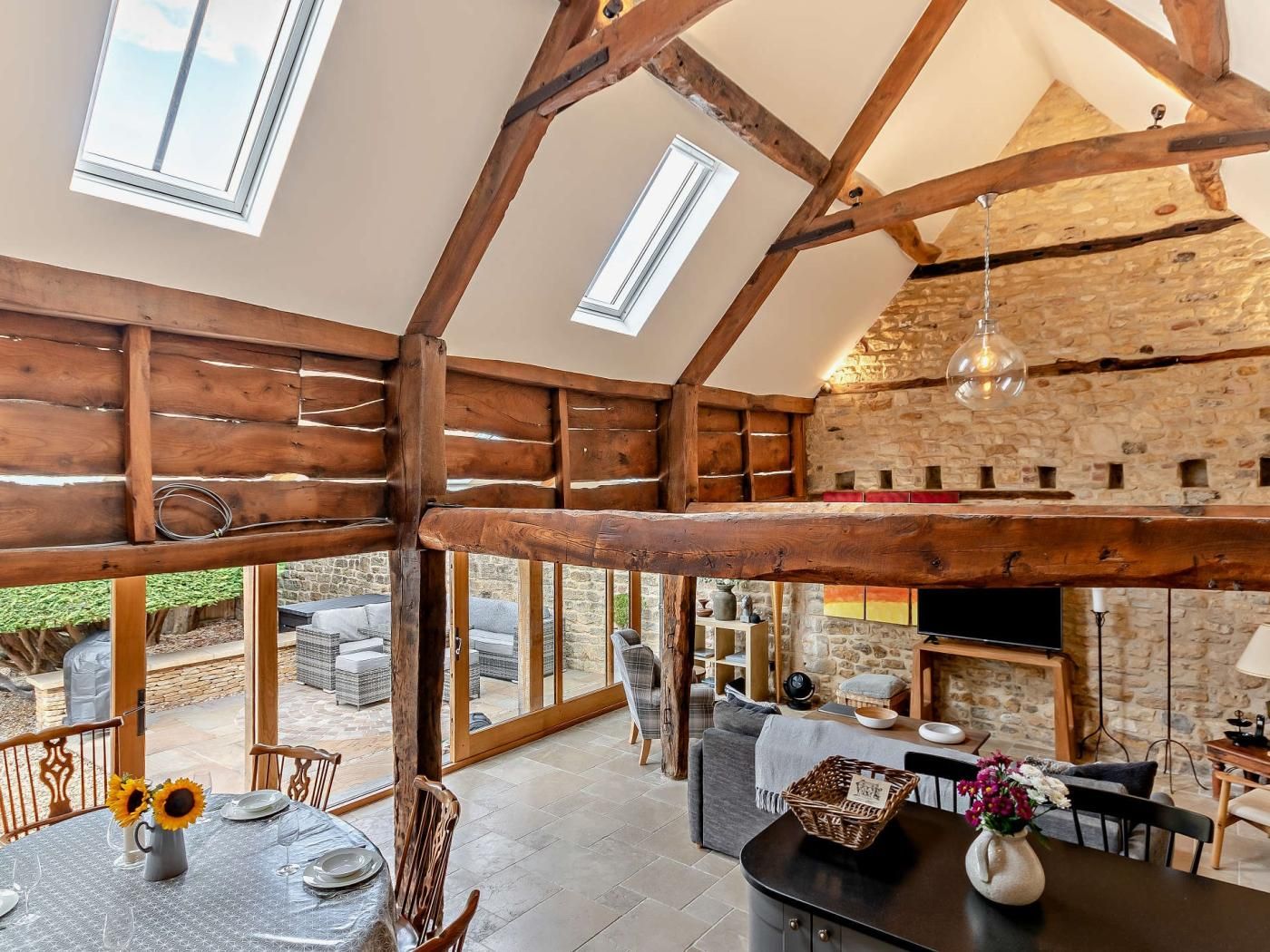A spacious interior with high ceilings, wooden beams, and large windows.