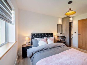 A bedroom with a bed, bedside tables, a lamp, a chair, a wardrobe, and a window. - 3 Bed in Carlisle (oc-94673) (Arthuret)