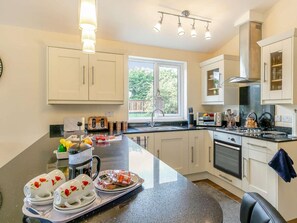 A modern kitchen with a large island, built-in appliances, and a window providing natural light. - 2 Bed in Malton (oc-87936) (West Heslerton)