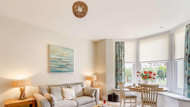 A living room with a sofa, coffee table, and dining area with chairs. - 2 Bed in Filey (oc-85246) (Filey)