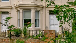 A corner bay window of a building with a brick base and a white door. - 2 Bed in Filey (oc-85246) (Filey)