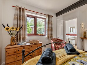 A bedroom with a bed, a wooden dresser, a window with curtains, a chair, and a view of the outside. - 1 Bed in Wells (oc-94958) (Wookey)