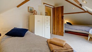 Een slaapkamer met een hoogslaper, een kledingkast en een klein bureau.