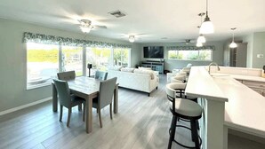 Amplia sala de estar con mesa de comedor, sofás y cocina con una isla grande.