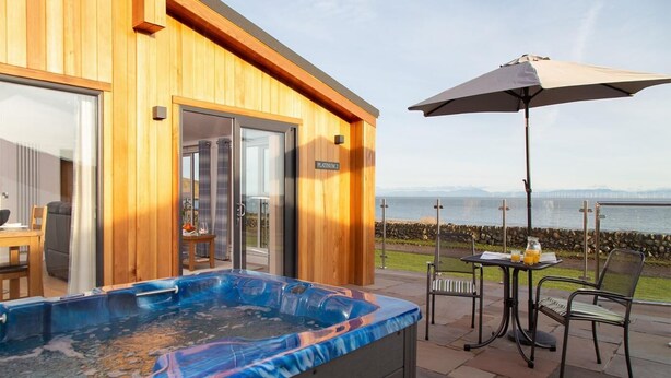 Une construction en bois dotée d’un bain à remous, d’un espace extérieur aménagé et offrant une vue sur l’eau.