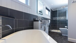 Une salle de bain moderne avec une baignoire sur pieds, un espace douche et des toilettes.