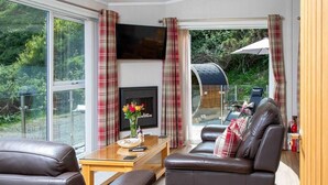 A modern living room with leather sofas, a flat-screen TV, and a fireplace. - 1 Bed in Castle Douglas (oc-rasc2) (Auchencairn)