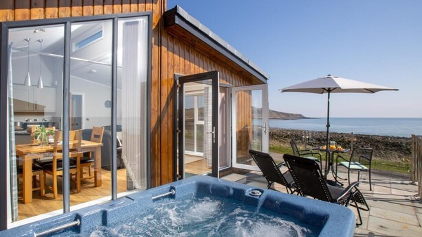 Una casa moderna con jacuzzi, comedor y vista al mar.
