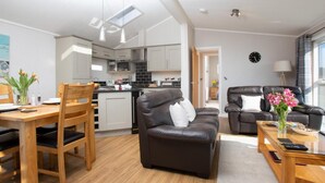 Un apartamento moderno con comedor, sala de estar con sofá, cocina y vista al exterior.