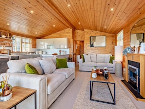A cozy cabin interior with a living area, kitchen, and a fireplace. - 3 Bed in Ilfracombe (oc-95047) (Ilfracombe)