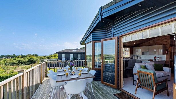 Een terras met een eettafel, een zithoek met een bank en uitzicht op het landschap.