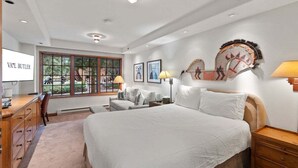 A bedroom with a large bed, a desk, and a TV. - Studio - Ski In/Ski Out Vail Village 204 (Vail)