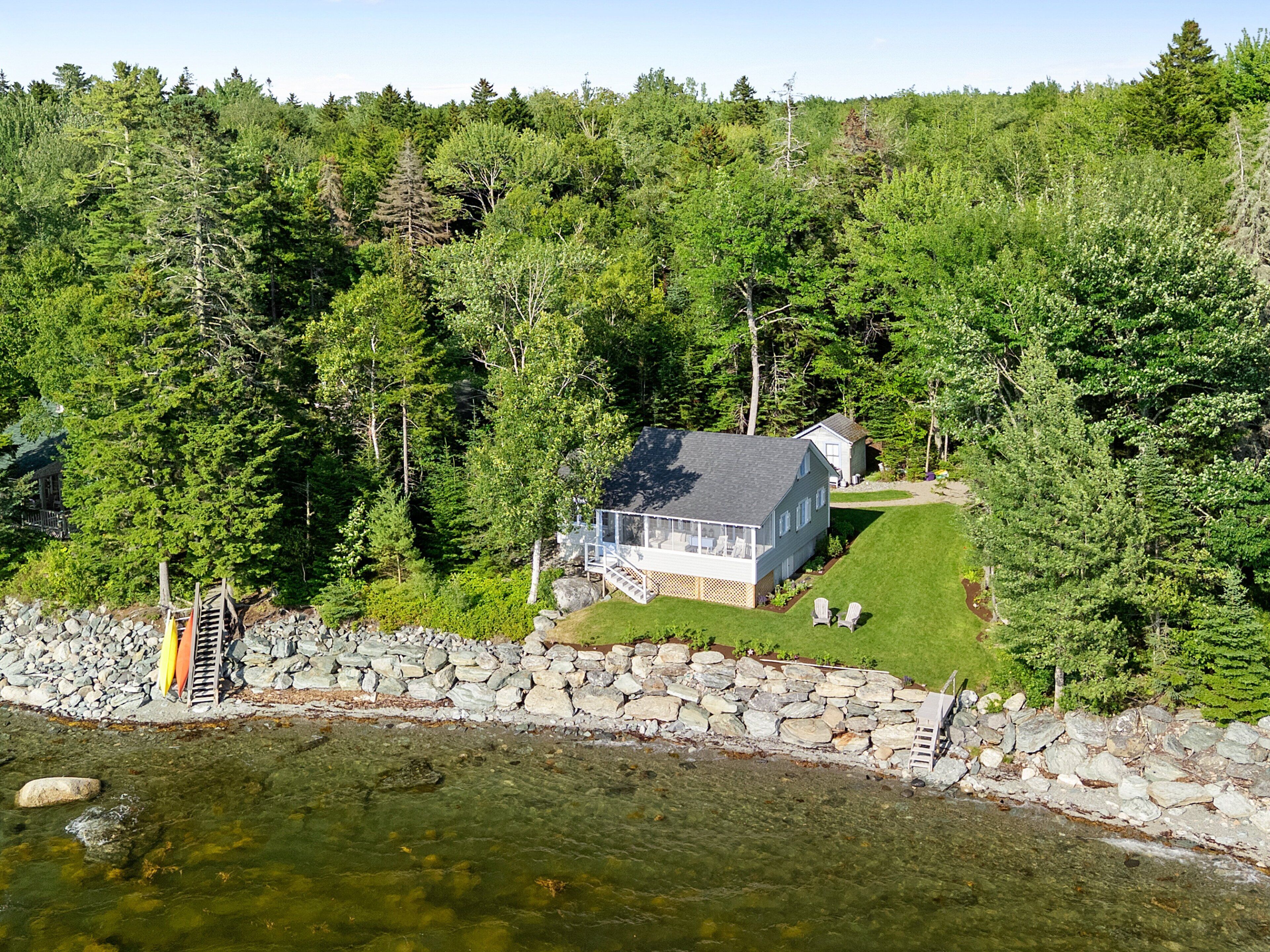 A house surrounded by dense forest, with a clear view of the surrounding nature.