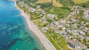 Une ville côtière dotée d’une plage, de quartiers résidentiels et, en arrière-plan, de collines douces.