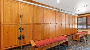 Eine Umkleidekabine aus Holz mit Bänken und einem Ski-Stock-Gestell.