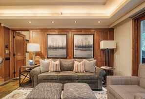 A cozy living room with a sofa set, two framed paintings, and a lamp on a side table. - Ski-in/out Vail Village condo with fireplace, balcony, and mountain views. (Vail)