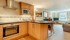 Una cocina moderna con armarios de madera, electrodomésticos de acero inoxidable y una isla central.