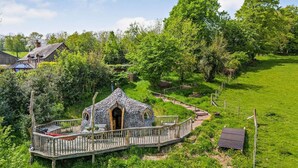 Une charmante maison en pierre avec une terrasse en bois et un petit jardin.