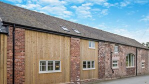Un bâtiment en briques doté de grandes portes et fenêtres en bois.