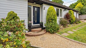 A house named 'Lyndale' with a front door, a small porch, and a garden with various plants and a gravel pathway. - 3 Bed in Yarmouth (oc-94802) (Cranmore)