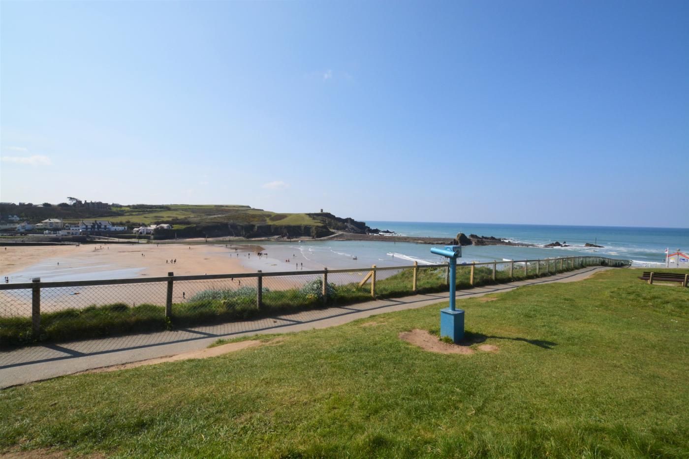 A coastal view with a beach, a walking path, and a lookout point.