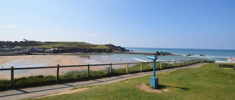 A coastal view with a beach, a walking path, and a lookout point.