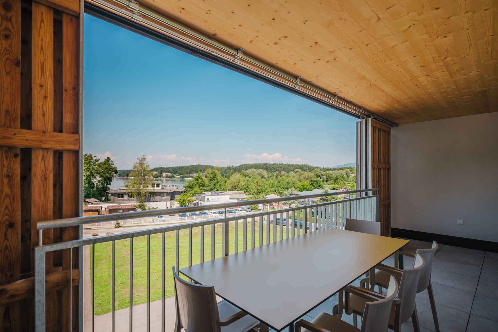 Un balcón con vista a una zona residencial, una mesa y sillas.