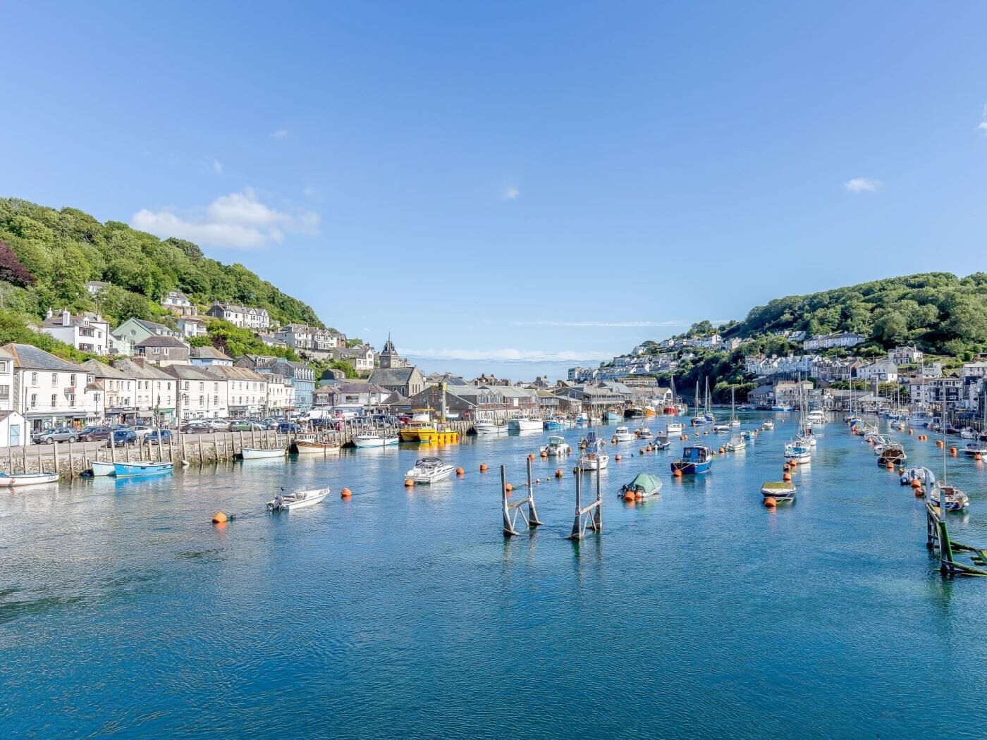 A harbor with boats, waterfront buildings, and a hilly backdrop.