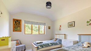 A bedroom with two beds, a window, a dresser, and a small table. - 3 Bed in Watchet (oc-95161) (Washford)