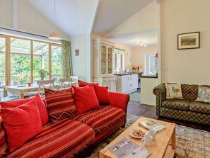 A cozy living room with a sofa, a dining table, and a kitchen area.