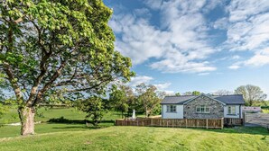 A house with a stone exterior, a fenced yard, and a large tree. - 2 Bed in Llanarth (oc-95322) (Llanarth)