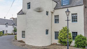 A white building with a steeply pitched roof, multiple windows, and a street lamp. - 3 Bed in Kelso (oc-95231) (Kelso)