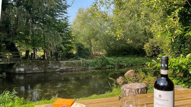 A picnic setup with cheese, crackers, and a bottle of wine by a river. - 3 Bed in Salisbury (oc-95325) (Amesbury)