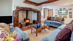 A cozy living room with a fireplace, a sofa, a coffee table, and framed pictures on the wall. - 3 Bed in Salisbury (oc-95325) (Amesbury)