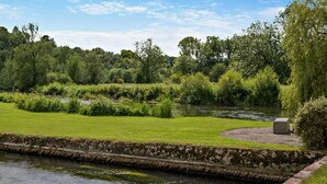 A river with a brick pathway and grassy banks. - 3 Bed in Salisbury (oc-95325) (Amesbury)
