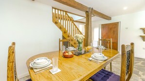 A dining area with a wooden table, chairs, and a staircase. - 2 Bed in Exeter (oc-93129) (Crediton Hamlets)