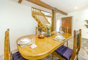 A dining area with a wooden table, chairs, and a staircase. - 2 Bed in Exeter (oc-93129) (Crediton Hamlets)