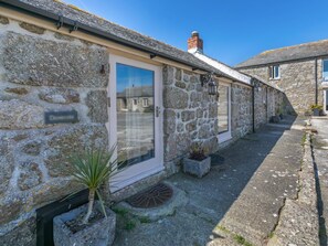 A stone building with a door, a small garden, and a pathway. - 1 Bed in Penzance (oc-92234) (Lamorna)