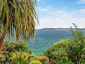 A coastal garden with a view of the sea and a distant landmass. - 1 Bed in Tenby (oc-95339) (Tenby)