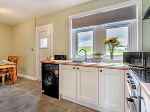 A kitchen with a dishwasher, stove, sink, and a window with a view of the outdoors. - 2 Bed in Carluke (oc-95359) (Carluke)