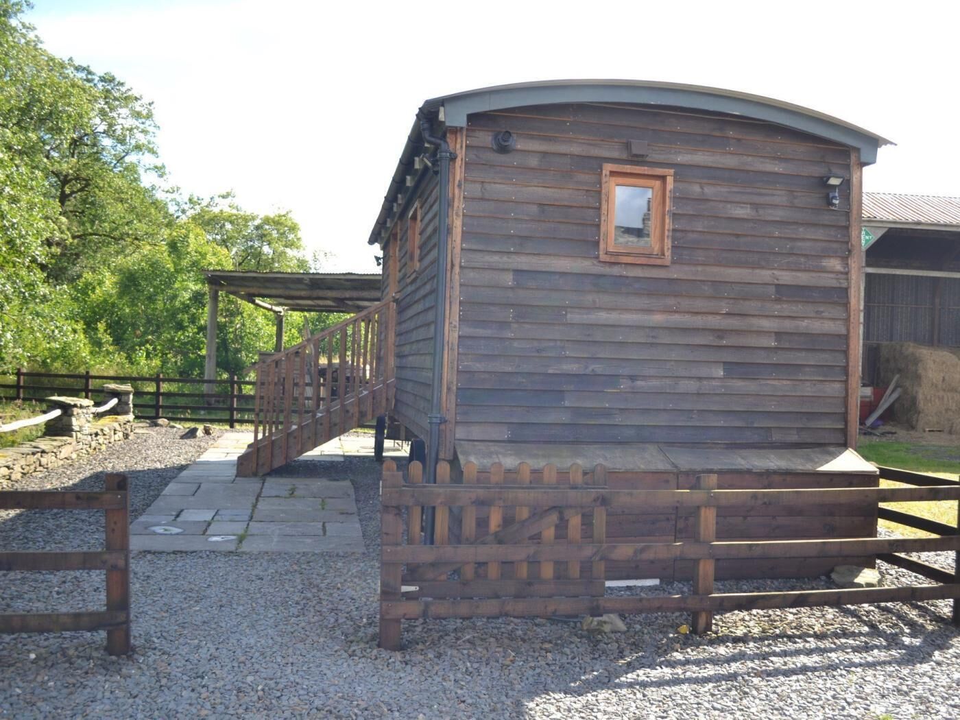 A wooden building with a curved roof, a wooden door, and a small window.