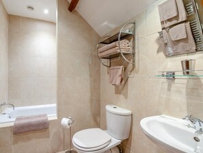 A bathroom with a toilet, sink, and bathtub. There is a towel rack with towels and a glass shelf with toiletries. - 5 Bed in Torrington (oc-knawo) (Frithelstock)
