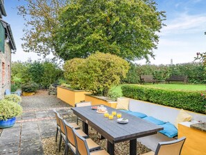 An outdoor patio area with a table set for dining, surrounded by chairs and a sofa. - 5 Bed in Torrington (oc-knawo) (Frithelstock)