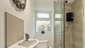 Ein Badezimmer mit Waschbecken, Toilette und Dusche.