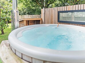 A hot tub in a backyard with a wooden deck and a window. - 2 Bed in Waterlooville (oc-95357) (Denmead)