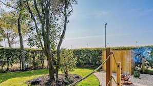 A rope bridge over a gravel path, surrounded by greenery and a wooden structure. - 1 Bed in Broxburn (oc-95472) (Broxburn)