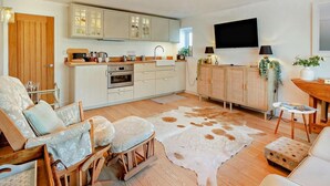 Une cuisine moderne avec des armoires blanches, un four encastré et un grand îlot central.