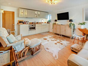 A modern kitchen with white cabinets, a built-in oven, and a large island. - 1 Bed in Hayle (oc-95418) (Phillack)