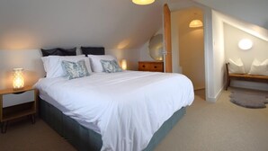 Une chambre à coucher avec un lit, des lampes de chevet, une commode et un miroir.